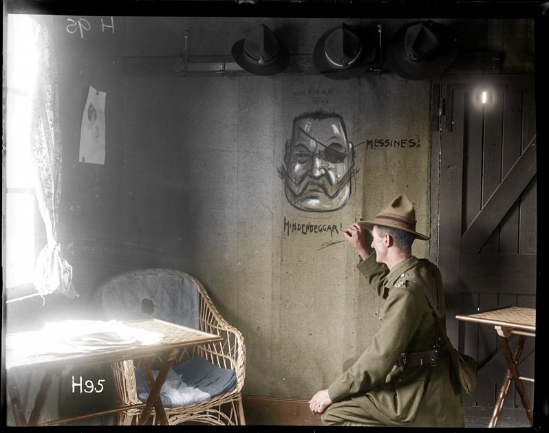 The New Zealand unofficial cartoonist (Lieutenant G. Pat Hanna) enlivens the walls of the officers club